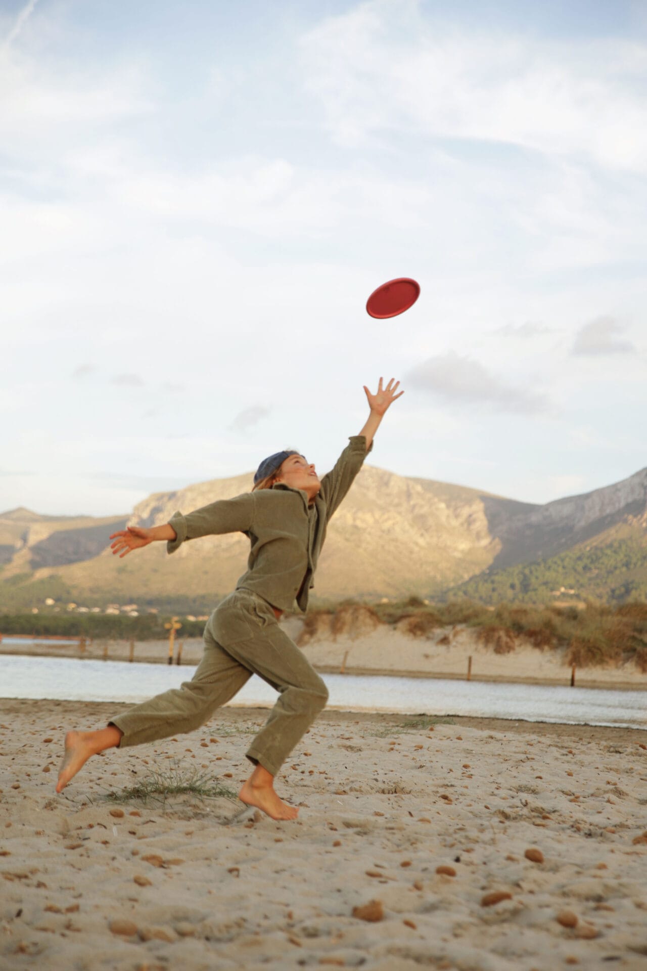 boy models running playing frisbee beach