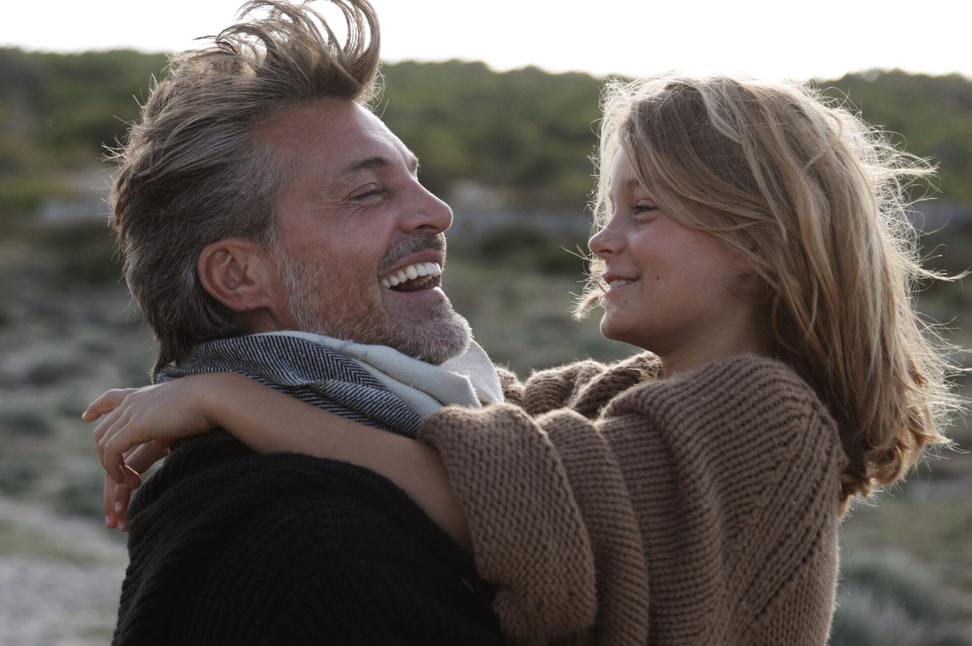 father holding son laughing