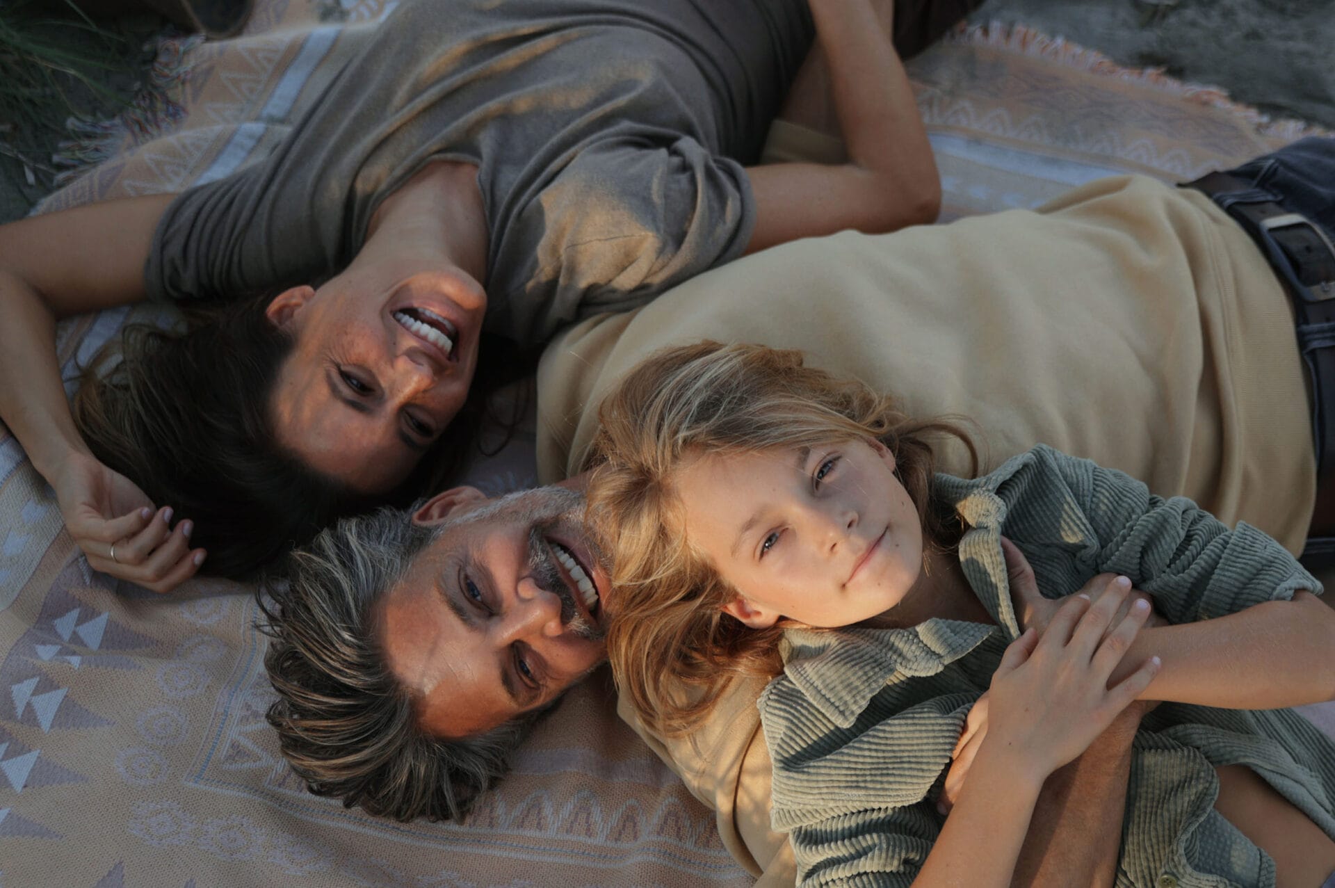 happy mallorca model family lying in the grass