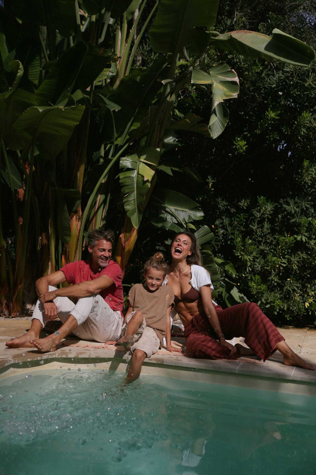 mallorca happy model family in garden laughing by the pool