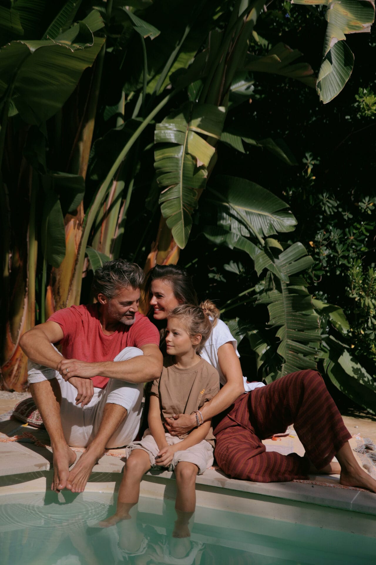 mallorca happy model family in garden smiling by the pool