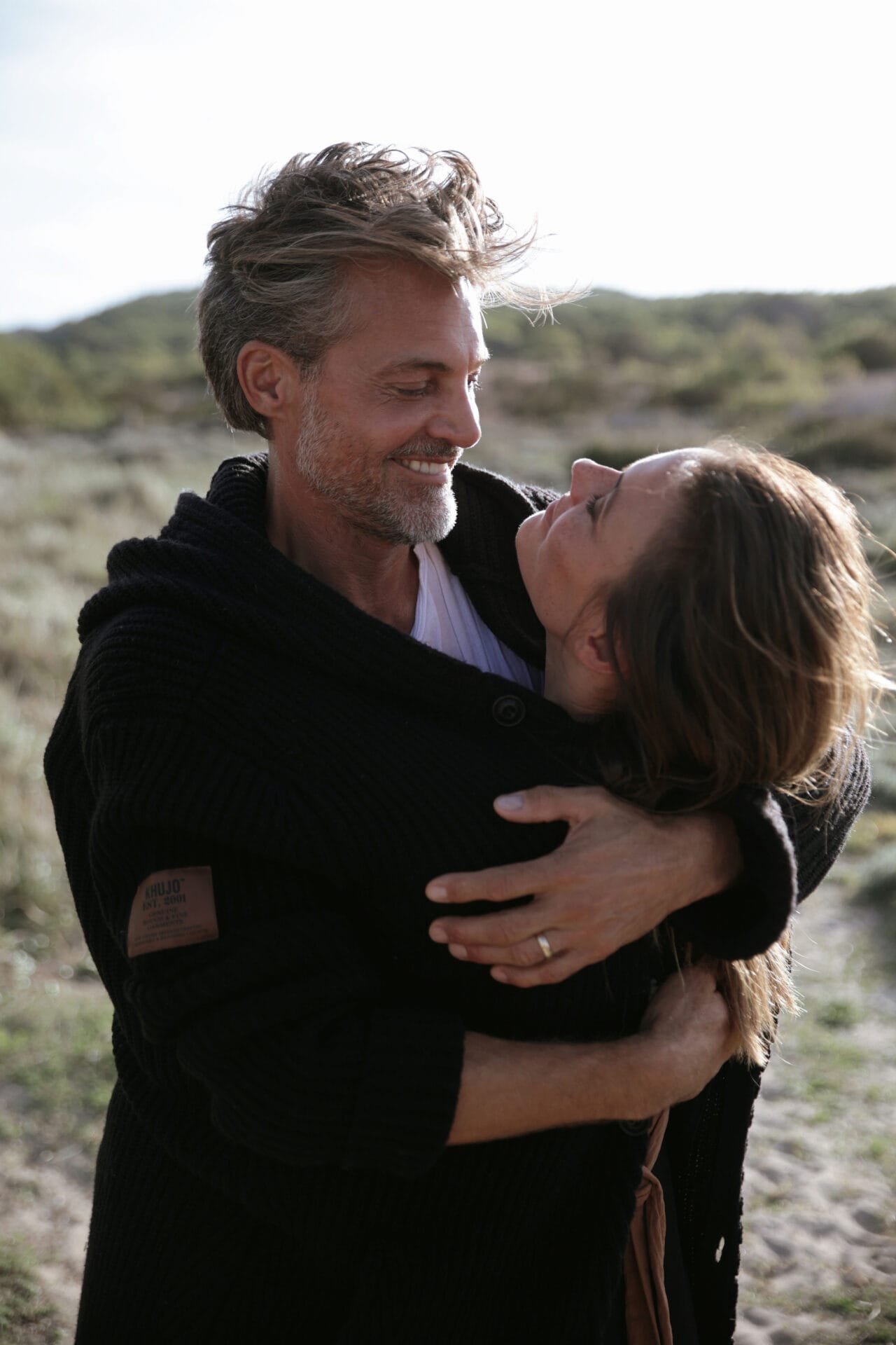 model couple mallorca hugging and laughing at the beach